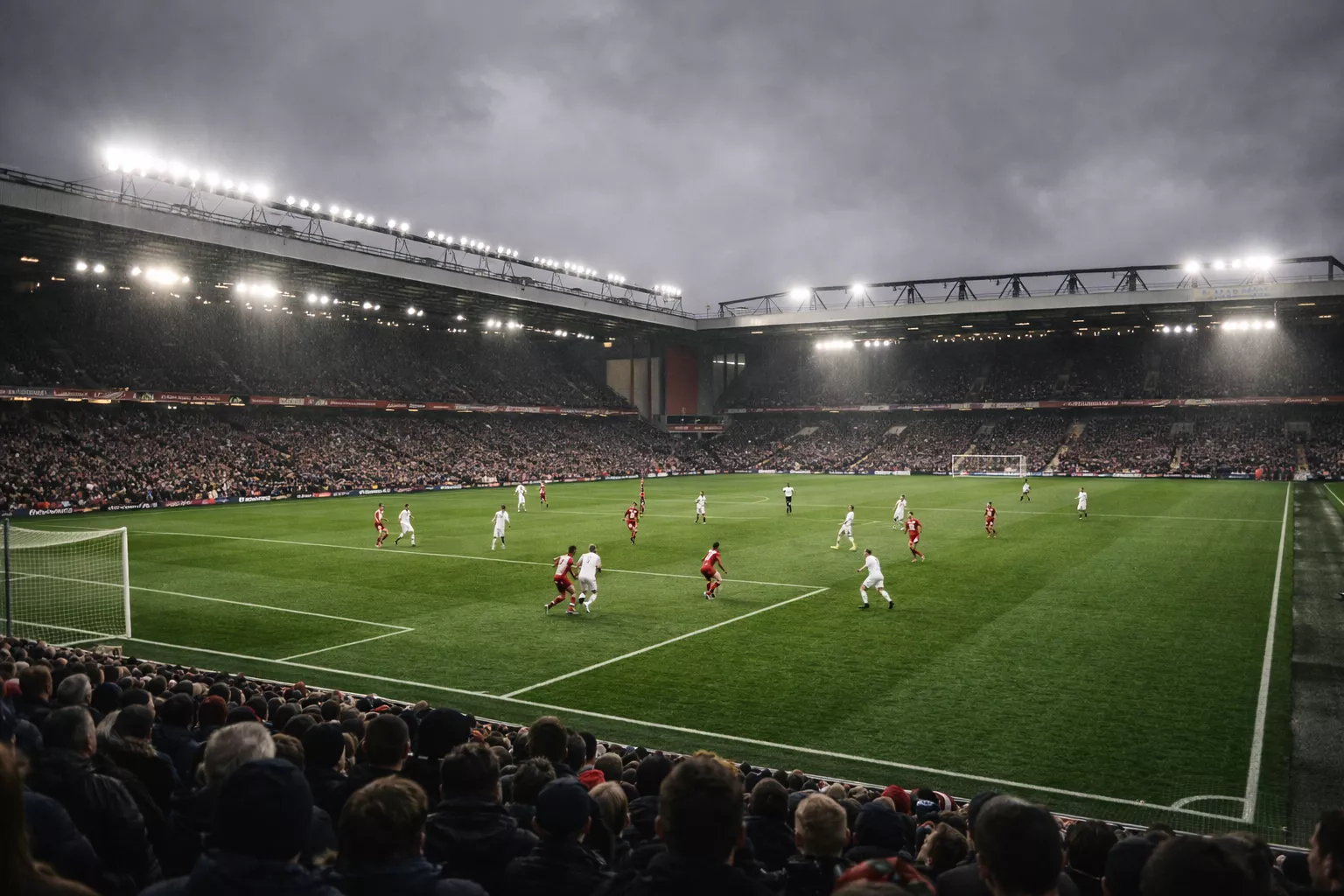 Partido de fútbol en un estadio inglés con césped verde intenso bajo cielo nublado y gradas llenas de aficionados