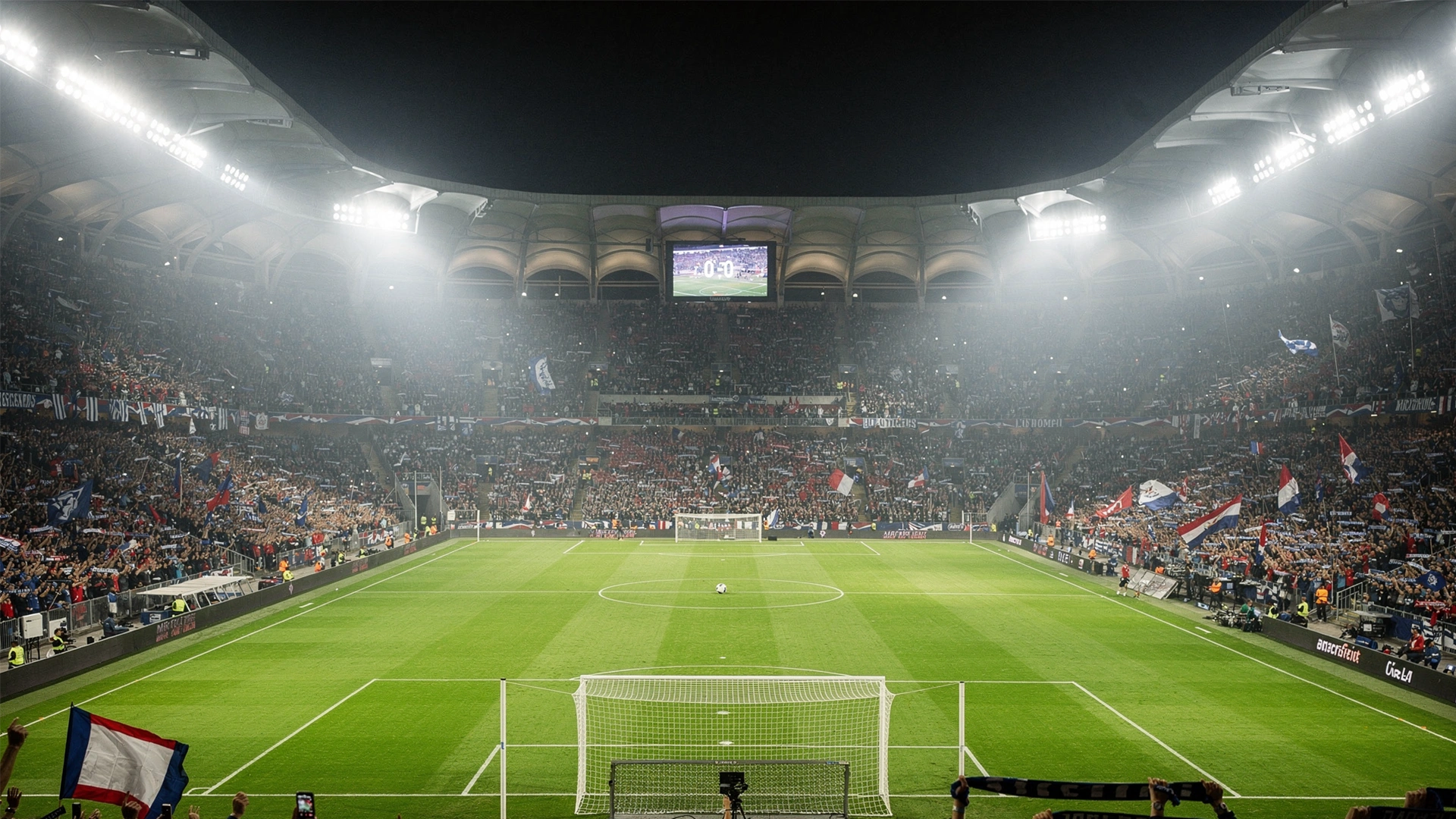Estadio de fútbol iluminado durante un partido nocturno con aficionados en las gradas